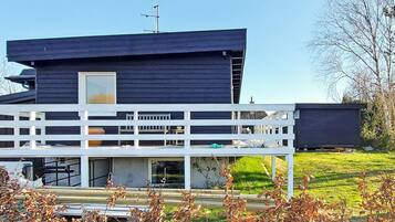 Een modern huis met twee verdiepingen, een balkon en een plat dak.
