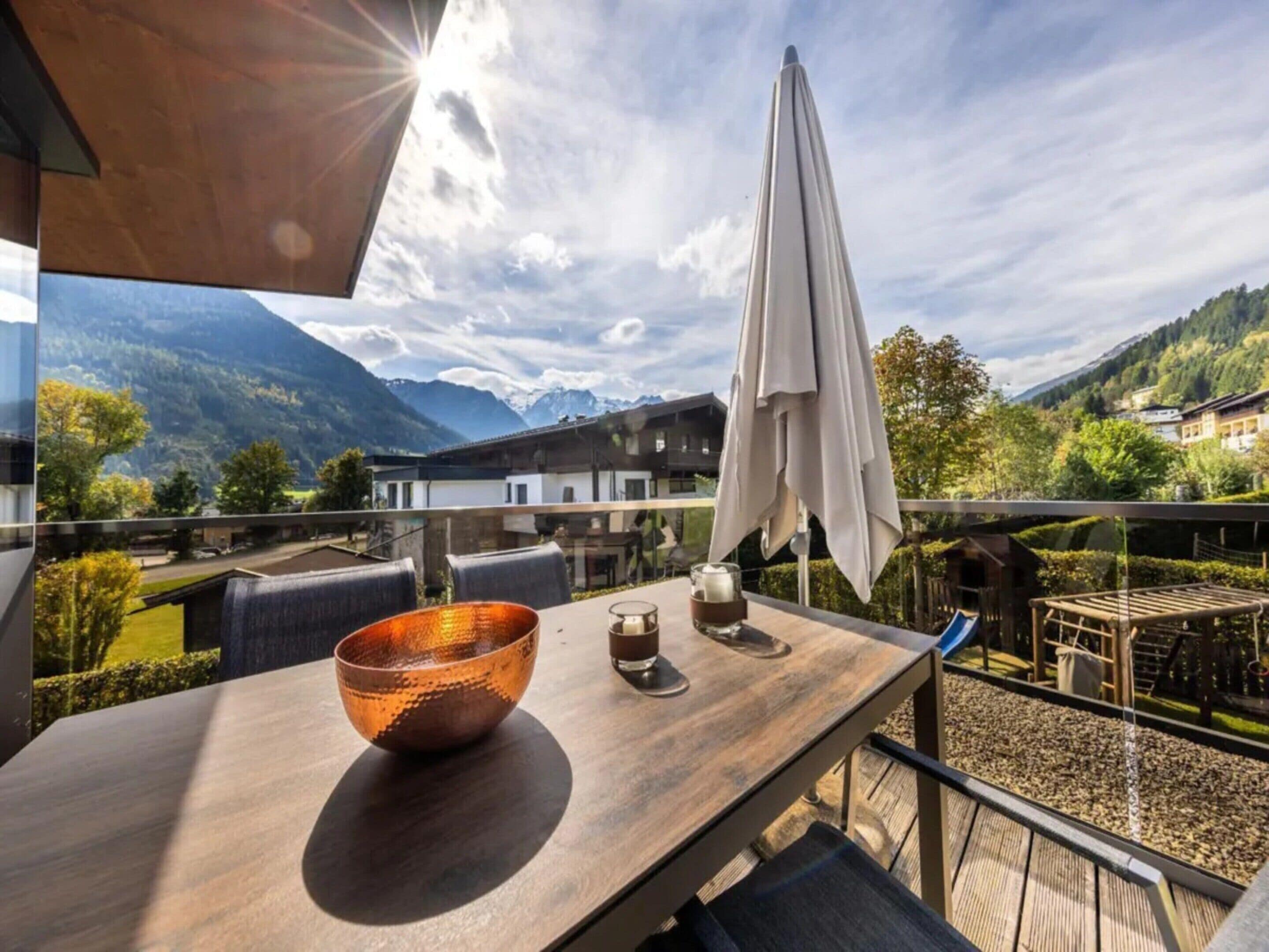 A dining area with a table, chairs, and a view of mountains.