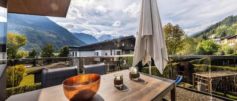 A dining area with a table, chairs, and a view of mountains.