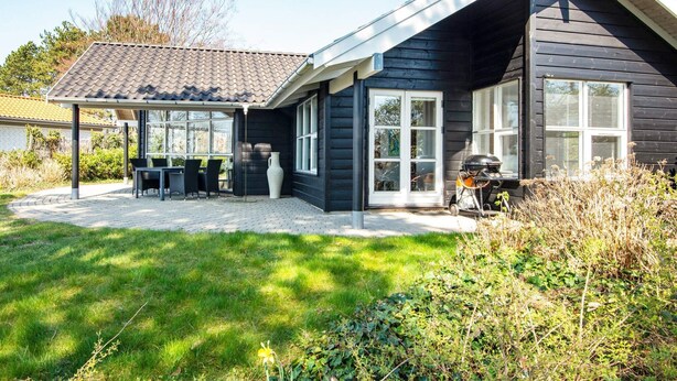 A house with a covered patio area, a barbecue grill, and a lawn. - Holiday Home in Ebeltoft (Ebeltoft)