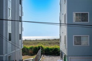 A view of a building with a clear sky and a distant body of water.