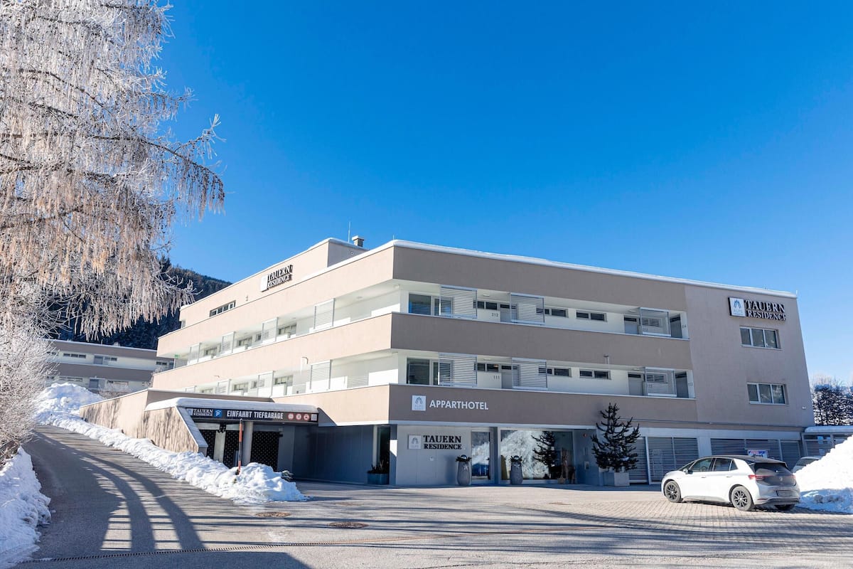 A multi-story building with a sign for 'Apparthotel' and 'Taurn Residence'.