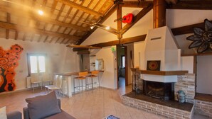 A spacious living area with a fireplace, a sofa, and a coffee table with magazines. - Holiday House in Filottrano on the Beach by the sea (Filottrano)