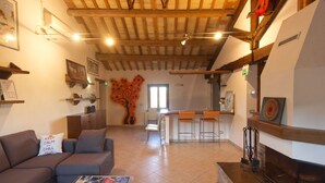 A spacious living area with a wooden ceiling, a fireplace, and a dining area with bar stools. - Holiday House in Filottrano on the Beach by the sea (Filottrano)