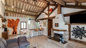 A spacious living area with a fireplace, a dining table, and a sofa. - Holiday House in Filottrano on the Beach by the sea (Filottrano)