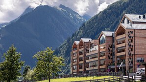 A wooden building with multiple balconies, surrounded by mountains and trees. - Large Apartment With Balcony & Terrace on Ski Slope (Rauris)