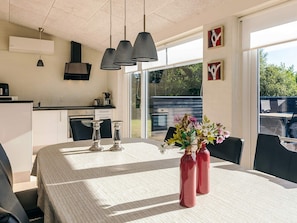 Una cocina moderna con comedor, ventanas amplias y vistas al exterior.