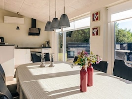 Una cocina moderna con comedor, ventanas amplias y vistas al exterior.