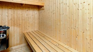 A sauna room with wooden walls and benches. - Holiday Home in Brovst (Brovst)