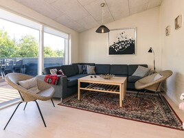 Una sala moderna con un sofá, una mesa de centro y sillas de mimbre.