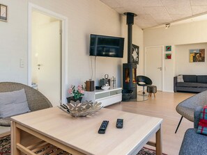 Una sala moderna con un televisor de pantalla plana, chimenea y asientos cómodos.
