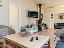 Una sala moderna con un televisor de pantalla plana, chimenea y asientos cómodos.