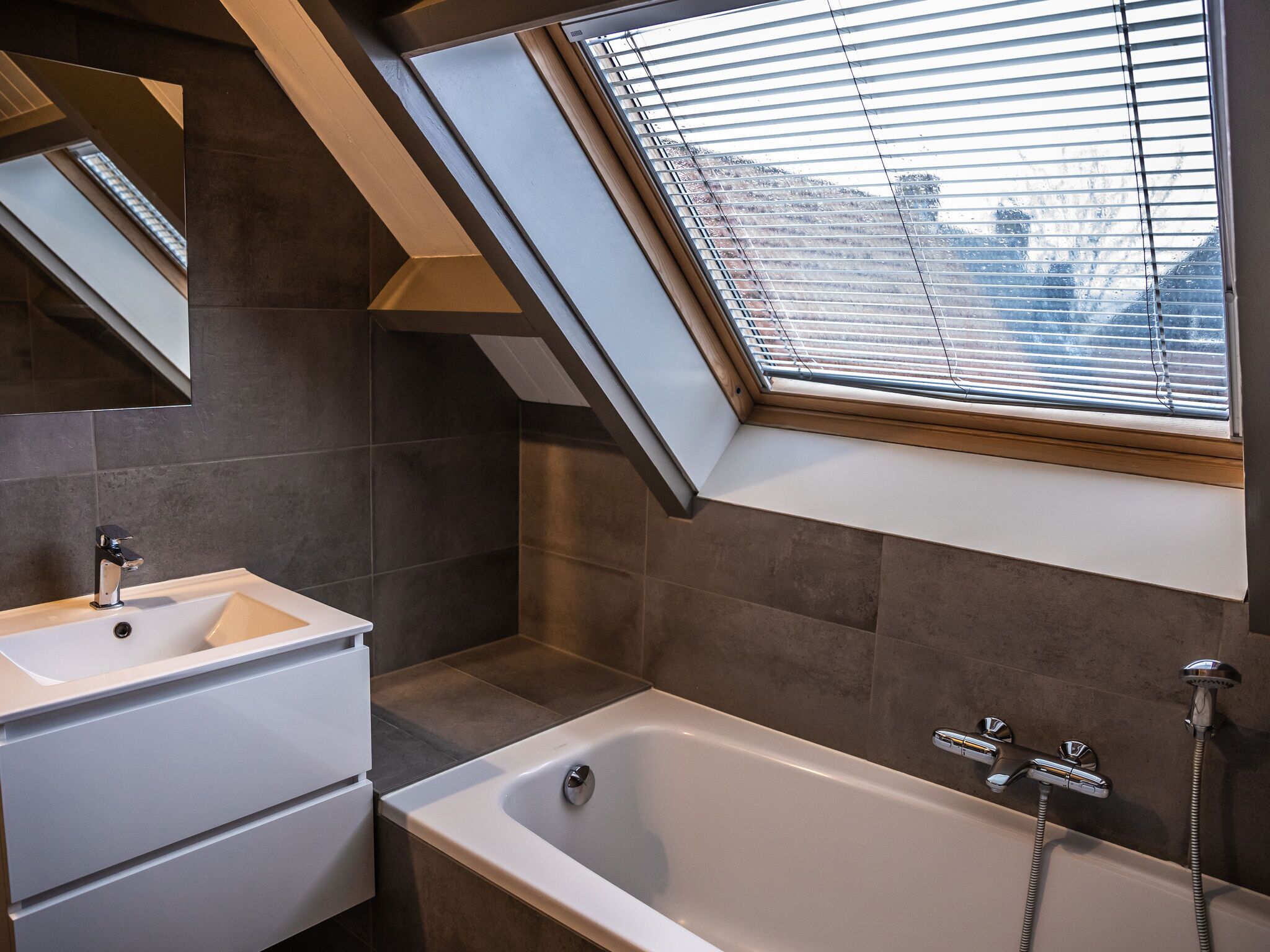 Ein modernes Badezimmer mit Oberlicht, Badewanne und Waschtisch.