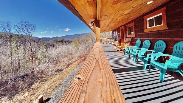 A wooden deck with turquoise chairs overlooking a dry landscape with mountains in the distance. - Sunset View over the Mountains! Rustic Cabin w/ Hot Tub (Almond)