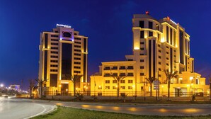 Un hotel de varios pisos con un llamativo letrero de "Residence Inn", que presenta un diseño arquitectónico moderno con ventanas iluminadas y una fachada bien iluminada.