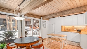 A modern kitchen with white cabinets, a wooden dining table, and a bench. - Quiet & Convenient With Great Amenities. Close To Downtown. Large Pool, HT, Fitness Rm. Parking (Aspen)