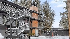 A multi-story building with a staircase, wooden paneling, and a gated entrance. - Quiet & Convenient With Great Amenities. Close To Downtown. Large Pool, HT, Fitness Rm. Parking (Aspen)