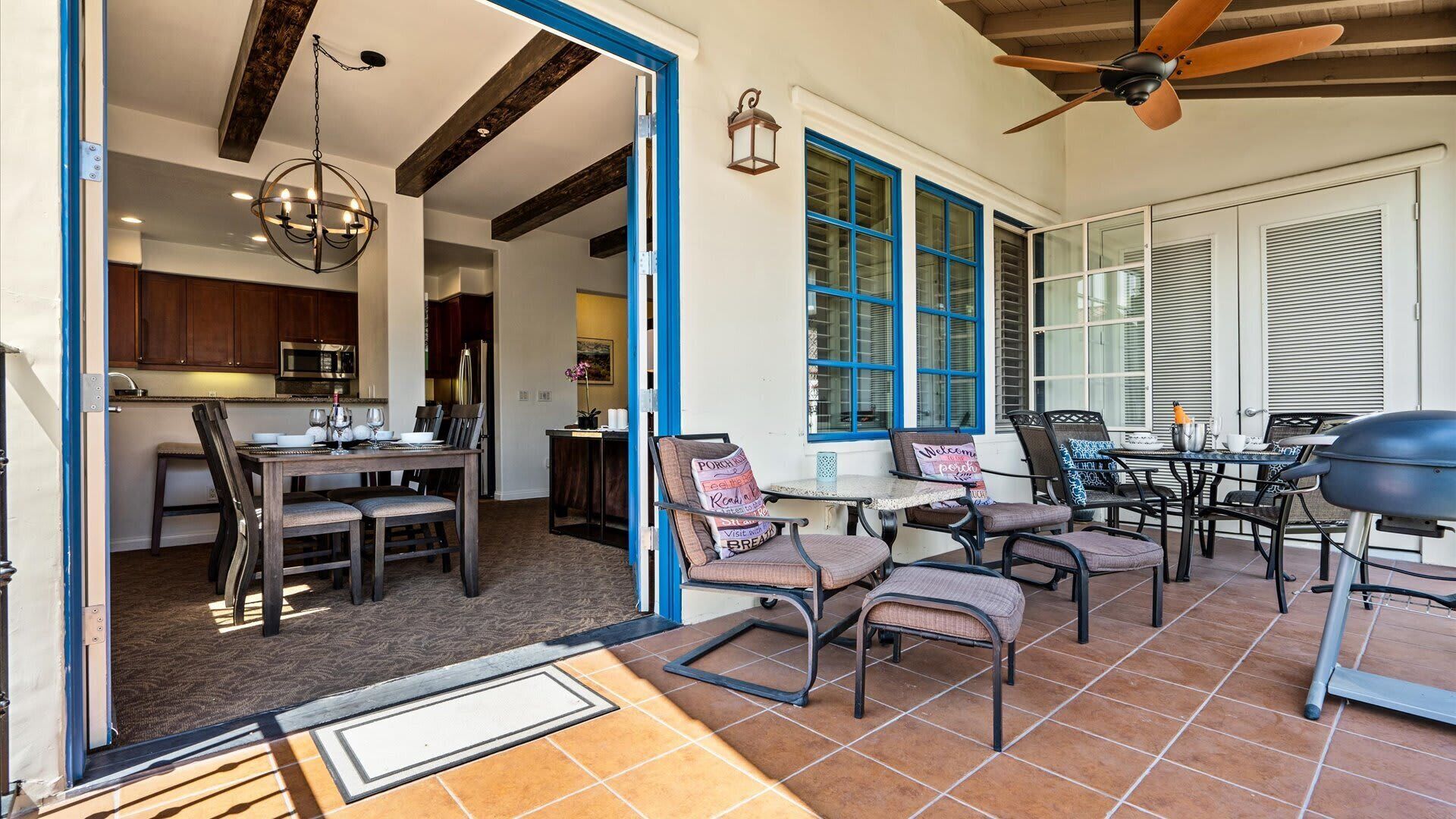 A patio area with outdoor seating, a ceiling fan, and a grill.