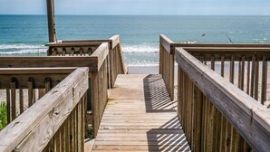 A wooden boardwalk leading to a beach with a wooden railing on one side and a wooden post on the other. - Casa Canal | Water Views + Pool, Hottub & Short Walk to Beach (Topsail Beach)