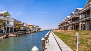 A waterfront property with a wooden dock leading to a marina. - Casa Canal | Water Views + Pool, Hottub & Short Walk to Beach (Topsail Beach)