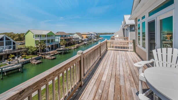 A wooden deck with a view of a marina and houses. - Casa Canal | Water Views + Pool, Hottub & Short Walk to Beach (Topsail Beach)