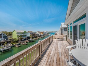 A wooden deck with a view of a marina and houses. - Casa Canal | Water Views + Pool, Hottub & Short Walk to Beach (Topsail Beach)
