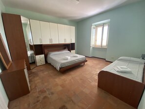 Cozy retreat with a central bed, wardrobe, and comfortable seating area.