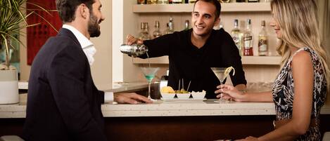 A bar setting with a bartender pouring a drink, a seated man, and a woman.