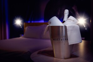 Ein metallenes Glas mit einer Flasche Moët & Chandon Champagner und einem Servietttuch auf einer Holztasse.