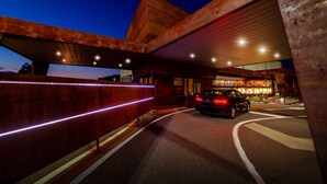 A modern building with a car driving under a bridge. - Motel Hotel Piranha (Casalino)