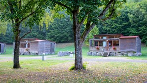 A rustic cabin with a wooden exterior, a porch with a railing, and a small staircase leading to the entrance.
