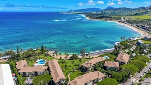 A resort with multiple buildings, a swimming pool, and a beach with clear blue waters. - Lae Nani 312, Oceanfront, AC,Tropical Bliss, Steps to Beach and Town (Kapaa)