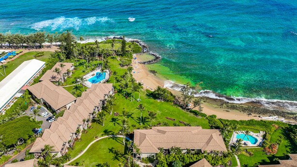 An aerial view of a resort with multiple swimming pools, a beach, and lush greenery. - Lae Nani 312, Oceanfront, AC,Tropical Bliss, Steps to Beach and Town (Kapaa)