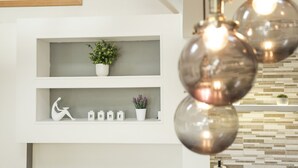 A modern interior with white shelves, decorative plants, and a minimalist design. - The Broadway Beach Homes Airbnb With Hot tub (Herne Bay)