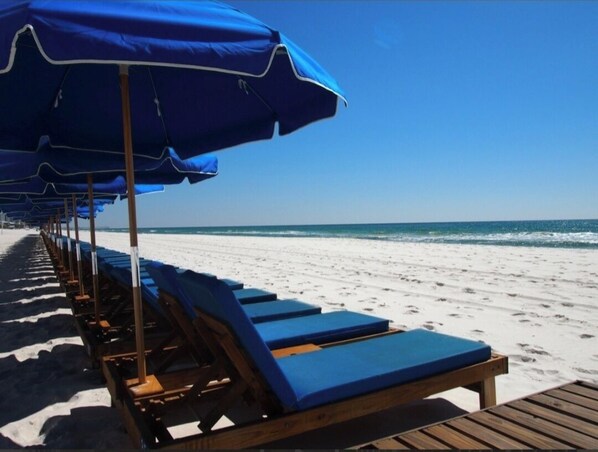 Relax in comfort by the ocean with a lounge chair and umbrella.