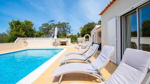 Un espace aménagé au bord de la piscine, avec des chaises longues et une piscine à l’eau d’un bleu limpide.