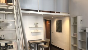 Un appartamento moderno e compatto, dal design open space, con angolo ristoro, angolo cottura e scaffalature integrate.