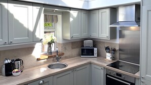 Una cocina moderna con tragaluz, electrodomésticos de acero inoxidable y encimera de madera.
