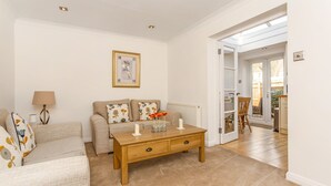 Una sala de estar con un sofá, una mesa de centro y una lámpara.