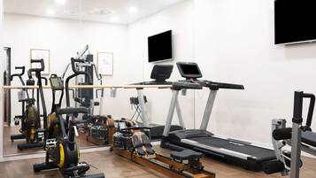A gym with cardio machines, a rowing machine, and a treadmill.