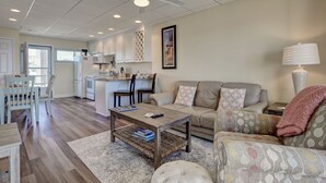 Een moderne woonkamer met een bank, salontafel en een eethoek.