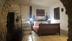 A bedroom with a bed, a painting, a lamp, and a staircase. - Character house 120m2, 3 ***, Grand Site de France, 2 panoramic terraces (Patrimonio)