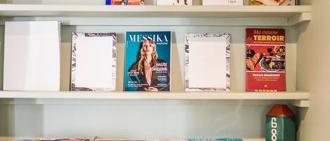 En samling böcker som står på hyllorna, bland annat titlar som ”SHOP” och ”MESSIKA MAGAZINE”.