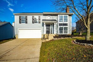 A two-story residential house with a garage, a front porch, and a well-maintained lawn. - 5388 Leaf Back · Lacinda`s Cozy Home (Beckett Ridge)