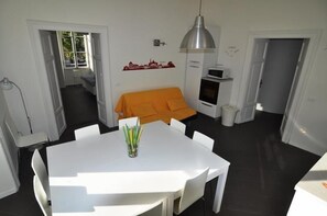 Cozy living space with a central dining table, comfortable sofa, and kitchenette area.