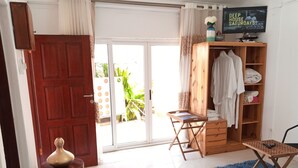 A room with a wooden wardrobe, a small wooden table, a blue shaggy rug, and a television displaying 'DEEP HOUSE SATURDAYS'. - Sparkle Guesthouse - Self-Catering with private pool and garden (Maputo)