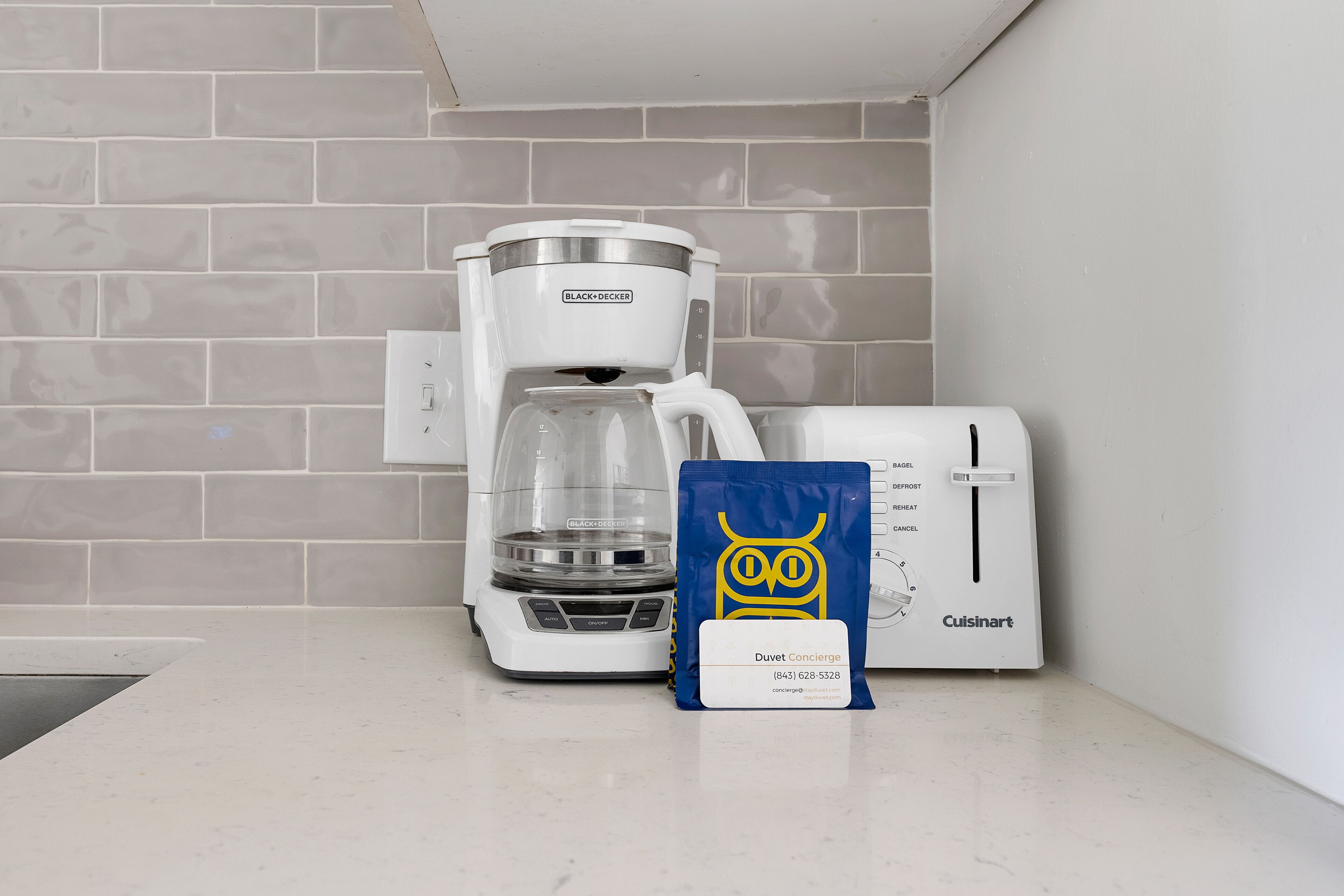 A coffee maker, a toaster, and a bag of Duvet Concerge on a kitchen counter.