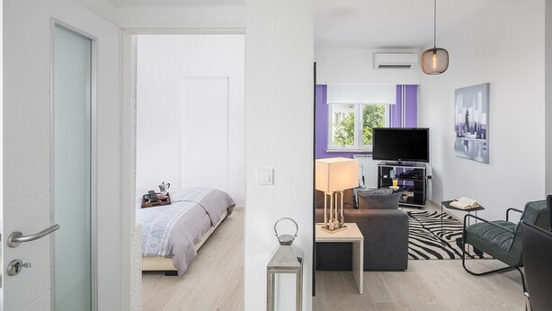 Un appartement moderne comprenant une chambre, un espace de vie et un coin repas.