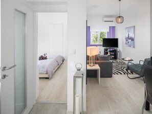 Un appartement moderne comprenant une chambre, un espace de vie et un coin repas.