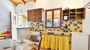 Cocina pequeña con armarios de madera, ventana y salpicadero de azulejos.